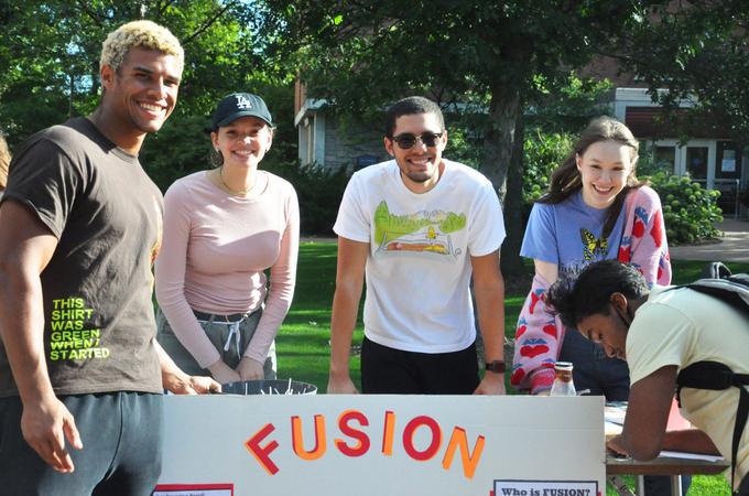 Hamline students behind a table with a sign Fusion 