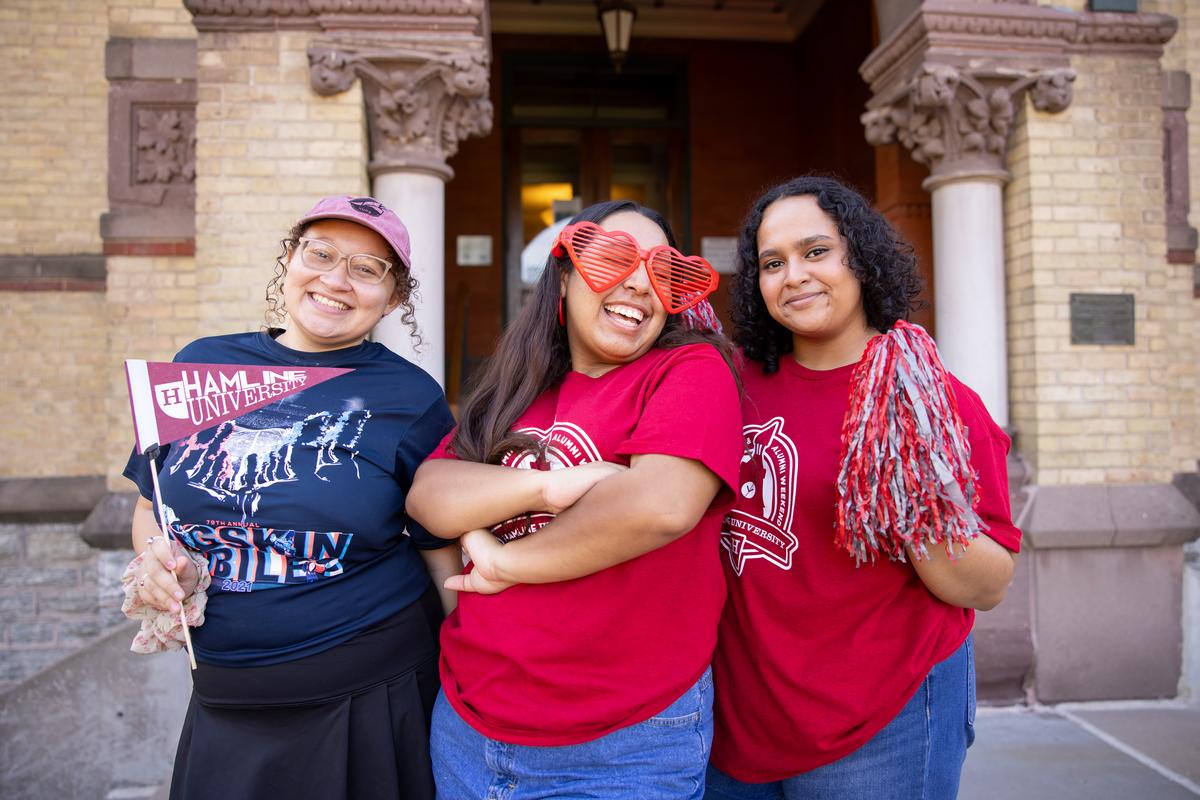 Three Hamline students with pennants at Homecoming