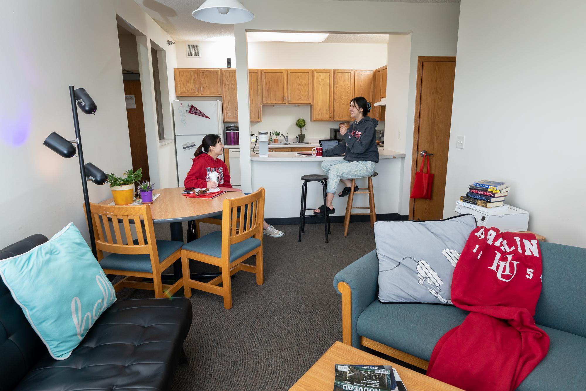 Interior of apartment in Hamline University Apartments, with two students sitting