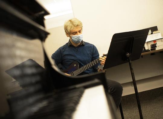 Hamline Music student Jesse Mickelson playing guitar in Hamline music room