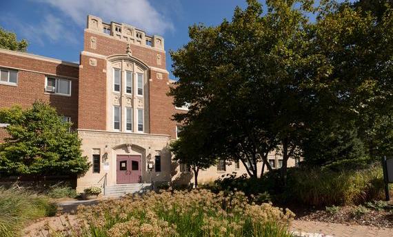 The front of Drew Residence Hall on Hamline's campus, the front doors framed by trees