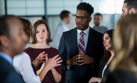 group of people standing and conversing with each other