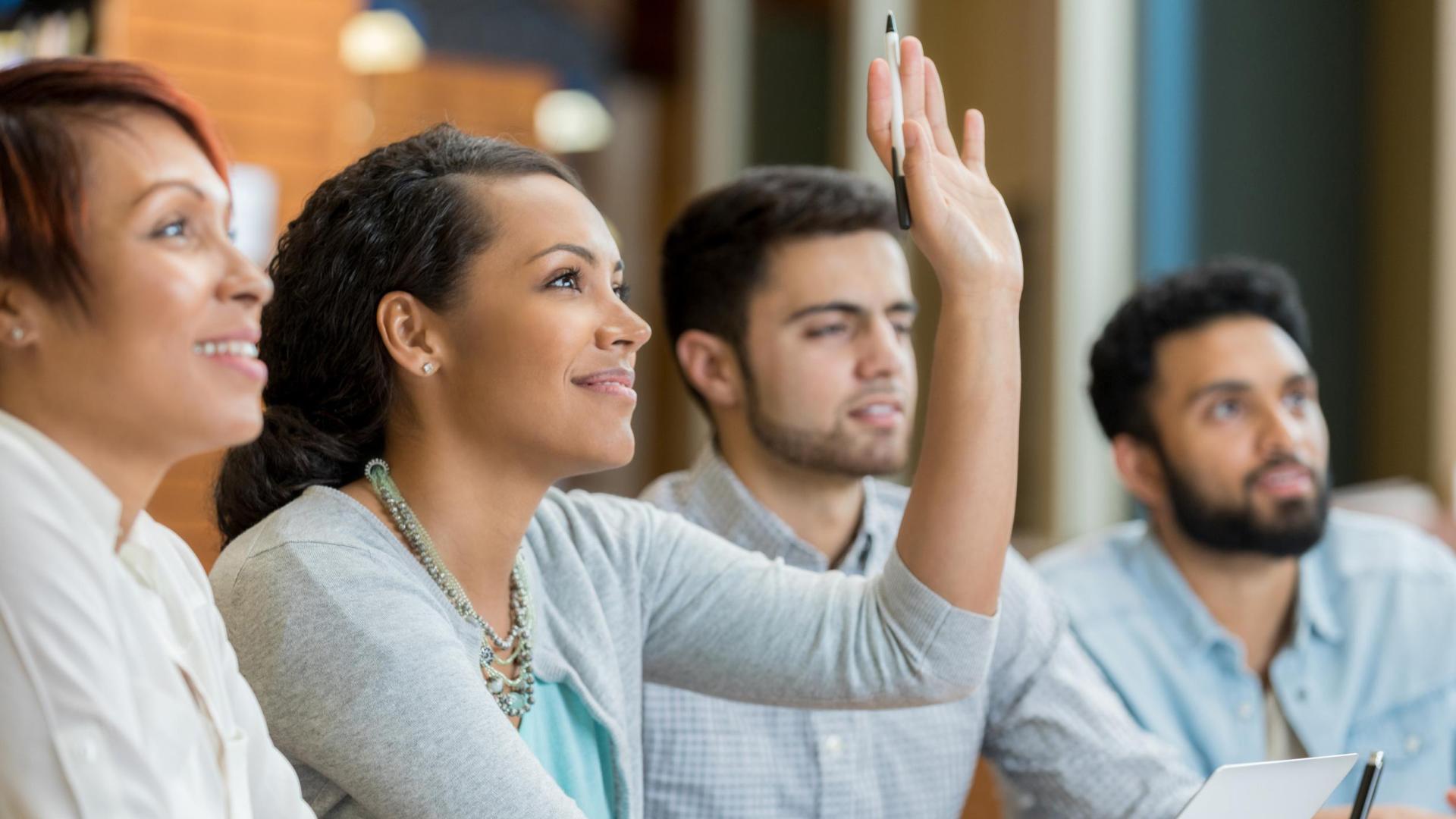 students raising hands in classroom