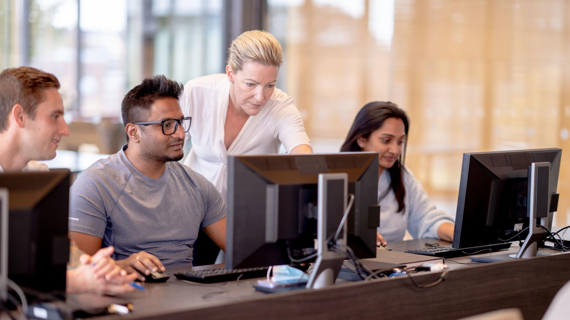 Diverse group of people looking at a monitor